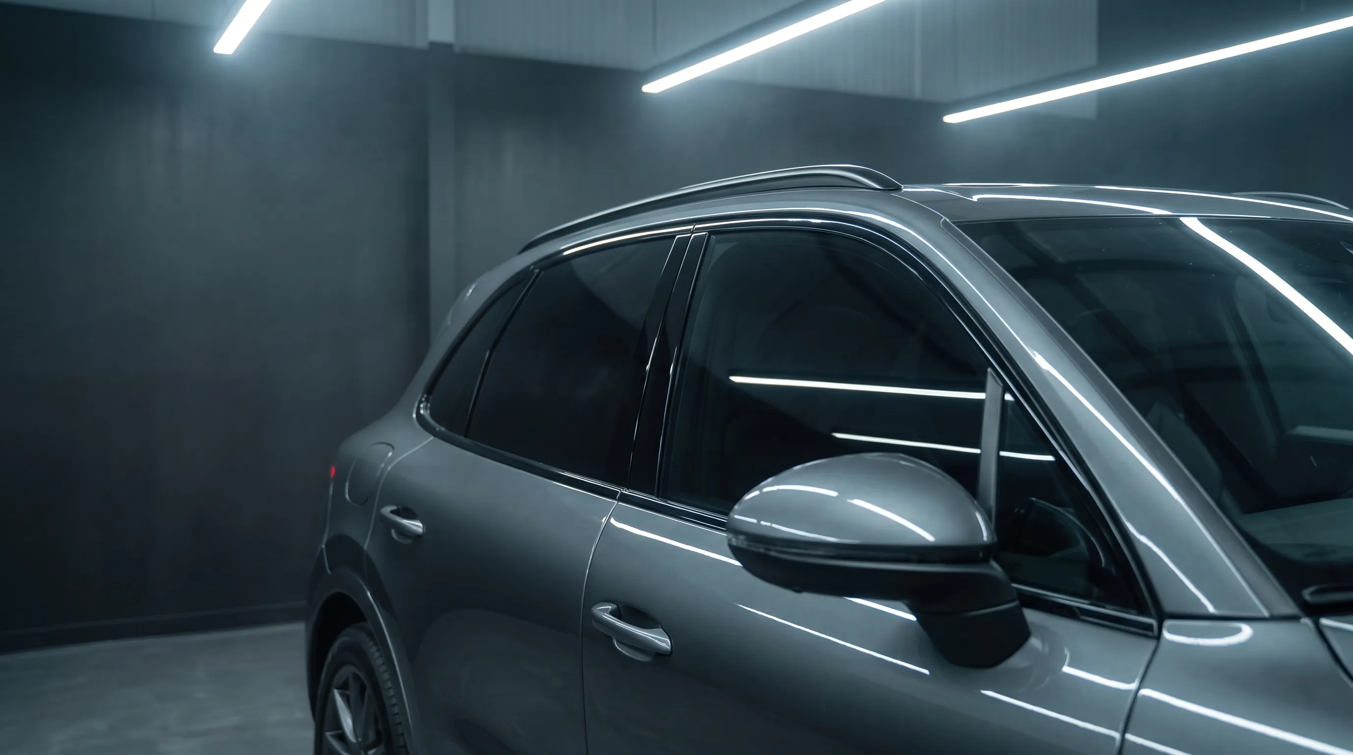 Side view of a charcoal SUV with dark ceramic tint on the side windows, darker than the windshield.